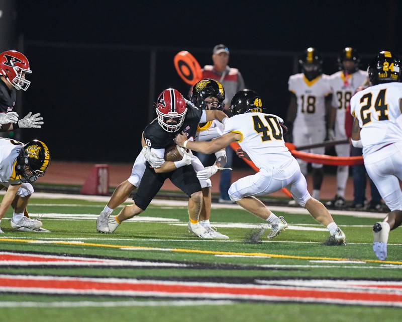 Yorkville's Joel Castillo (16) runs the ball before being brought down by Joliet West players during the game on Friday Sept. 5, 2025, held at Yorkville High School.