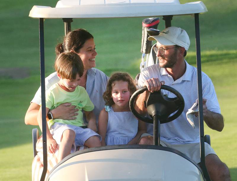 Jon Prescott rides in a golf cart with his family (from left) Mary, Charlie and Madeline during the Illinois Valley Mens Golf Championship Tournament on Sunday, July 27, 2025 at Spring Creek Golf Course in Spring Valley.