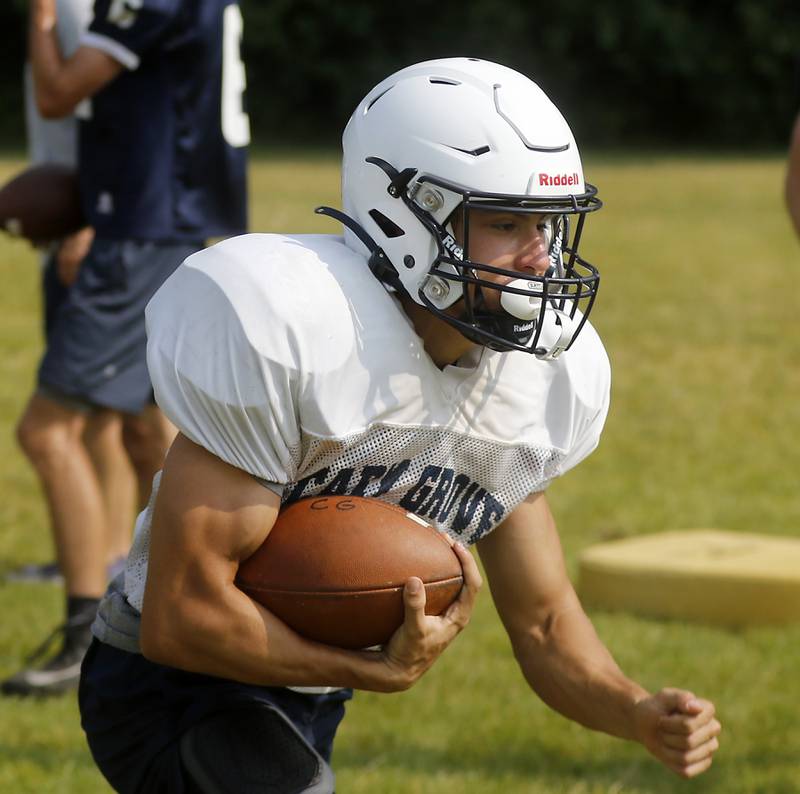 Cary-Grove’s Andrew Prio runs with the football during football practice Thursday, June 29, 2022, at Cary-Grove High School in Cary.