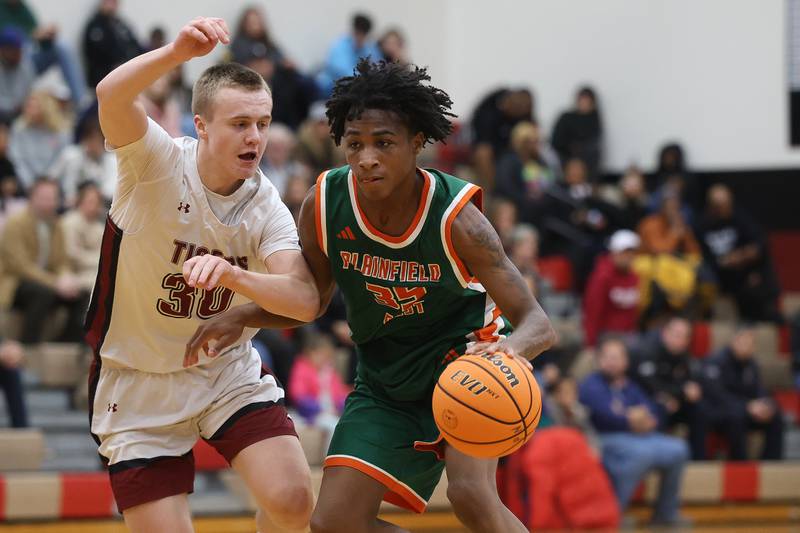 Plainfield East’s Alijah Little drives around Plainfield North’s Carson Miller on Tuesday, Dec. 9, 2025 in Plainfield.