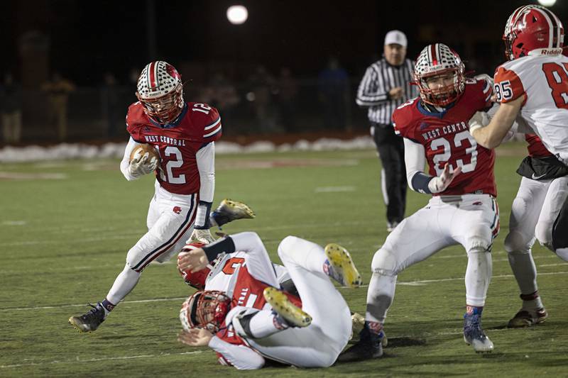 West Central’s Kaiden Droste hurdles a tackler Friday, Nov. 18, 2022 in the 8-man championship football game against Amboy.