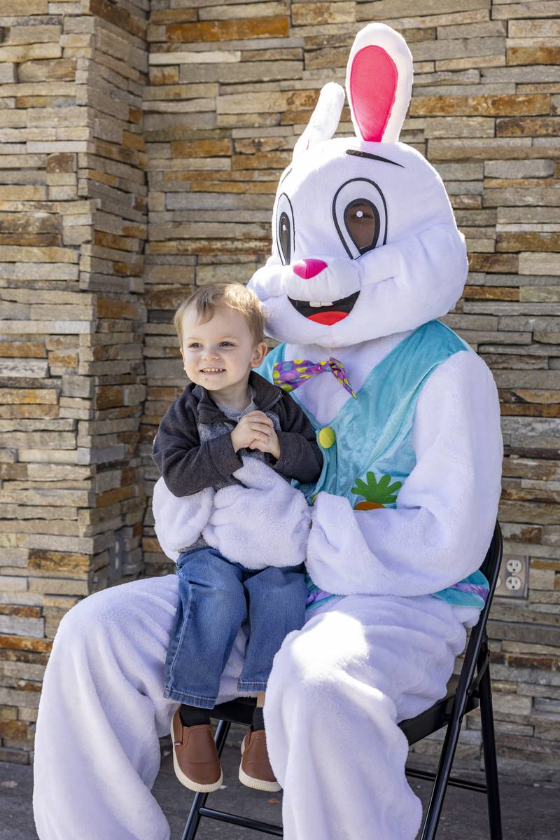 Oliver Haff smiles as his mother takes his photo on the Easter Bunny's lap during the Easter egg hunt on April 12, 2025 at Centennial Park in Peru.