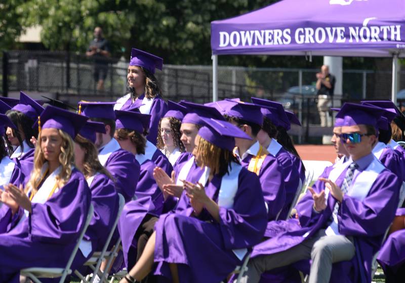 Downers Grove North graduates including Riley Petrauksas stand while being recognized for joining the US Military during the graduation ceremony Sunday May 21, 2023.