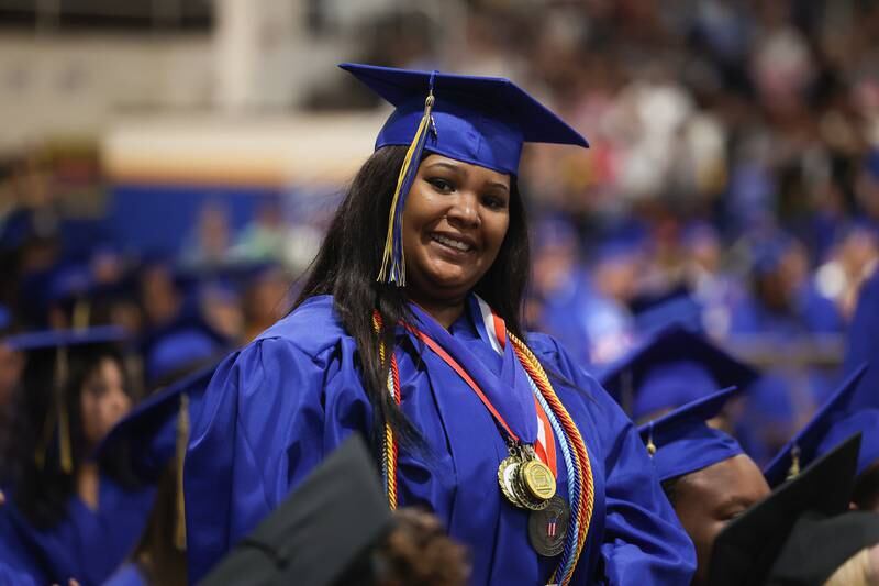 A graduate smiles for the camera as she stands in recognition at the Joliet Central Class of 2023 Commencement Ceremony on Saturday, May 20, 2023, in Joliet.
