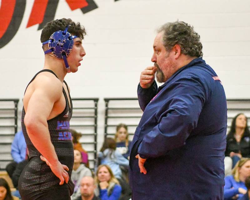 Anthony Haddad, left, of Marmion Academy talks with his coach during an injury timeout on Tuesday Feb. 25, 2025, in the regional meet held at Yorkville High School.