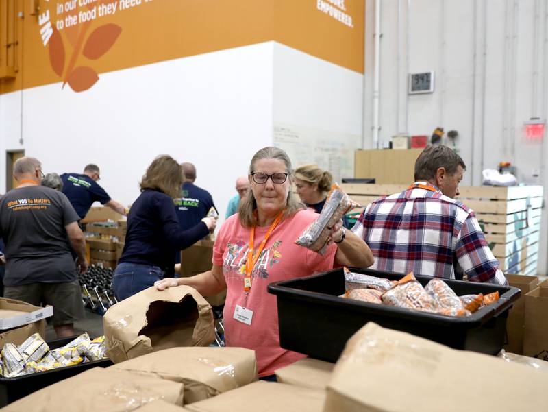 Volunteer Laura Walton of Naperville helps assemble holiday meal boxes on Tuesday, Oct. 29, 2024 at the Northern Illinois Food Bank in Geneva. This year marks the 25th anniversary of Northern Illinois Food Bank's Holiday Meal Box program.