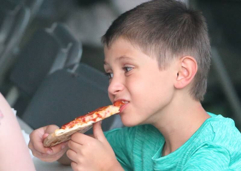 Isaac Mora-Nieto eats a piece of pizza during the Taste of the Illinois Valley festival on Saturday, Aug. 3, 2024 at Centennial Park in Peru.