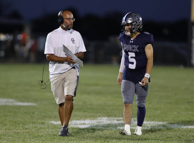 Oswego East head coach Tyson LeBlanc talks to Niko Villaci (5) during the varsity football game between Plainfield South and Oswego East on Friday, Sep. 20, 2024 in Oswego.