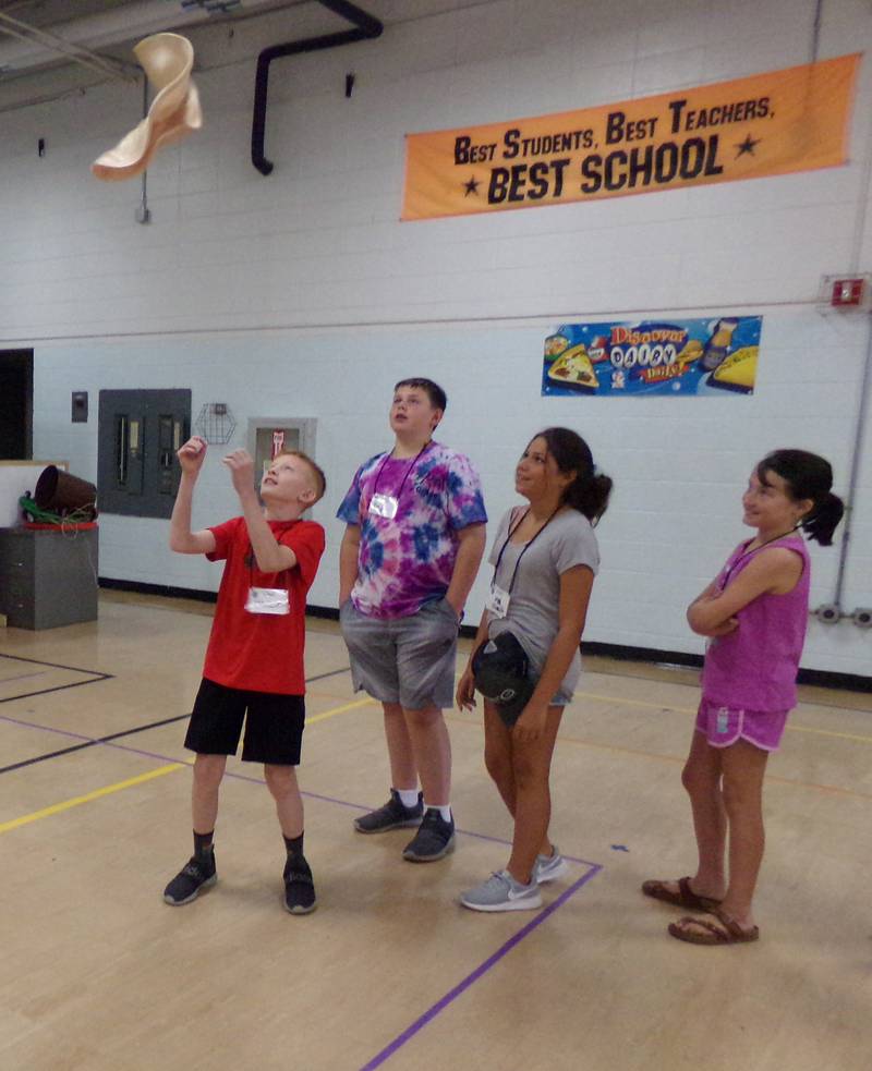 Students try their hand at tossing pizza dough Wednesday, June 22, 2022, at Northlawn School in Streator during an Illinois Young Chefs program led by the University of Illinois Extension.