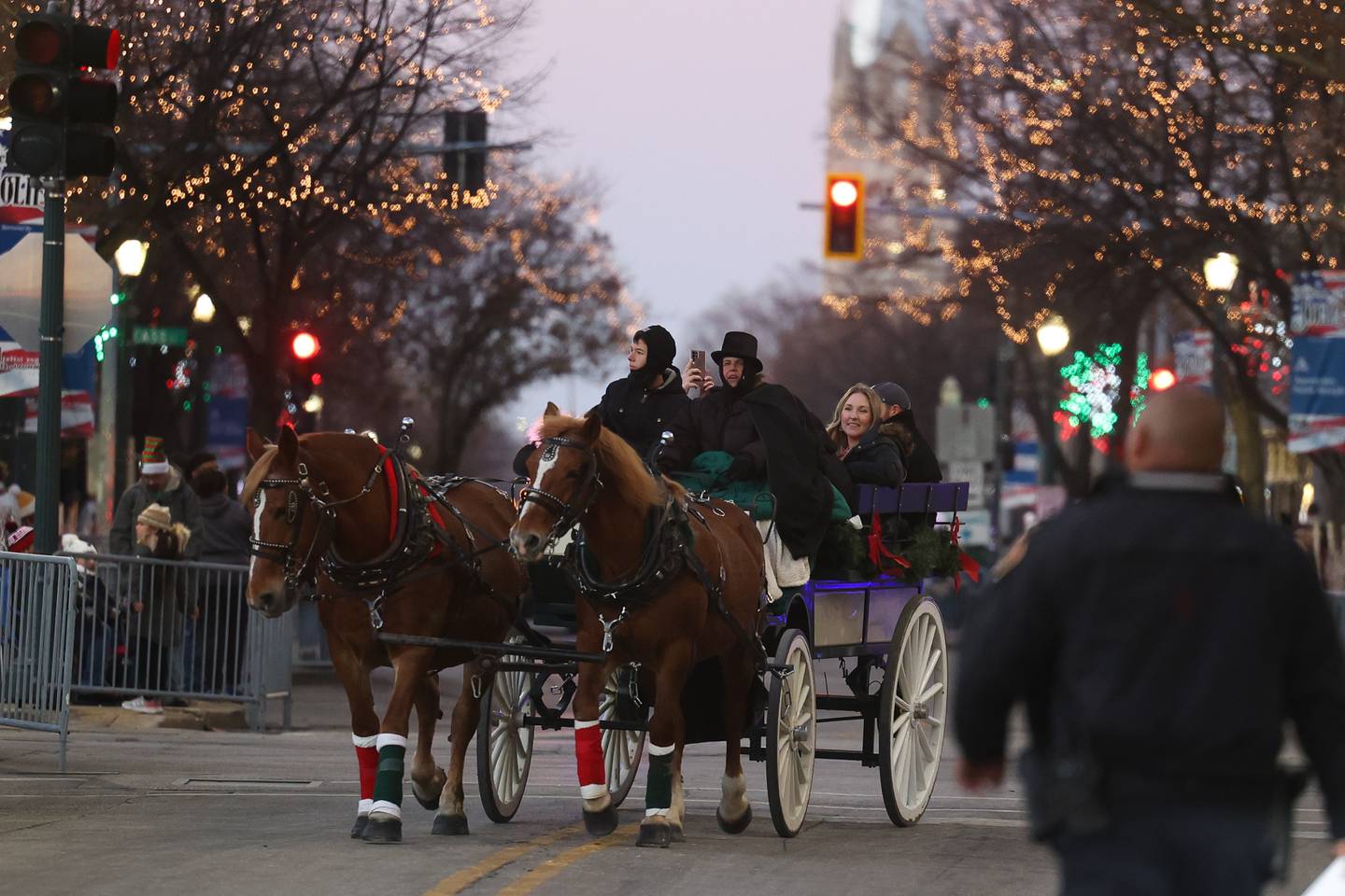 A horse drawn carriage takes riders along Chicago Street at the Light Up the Holidays Festival and Parade in downtown Joliet.