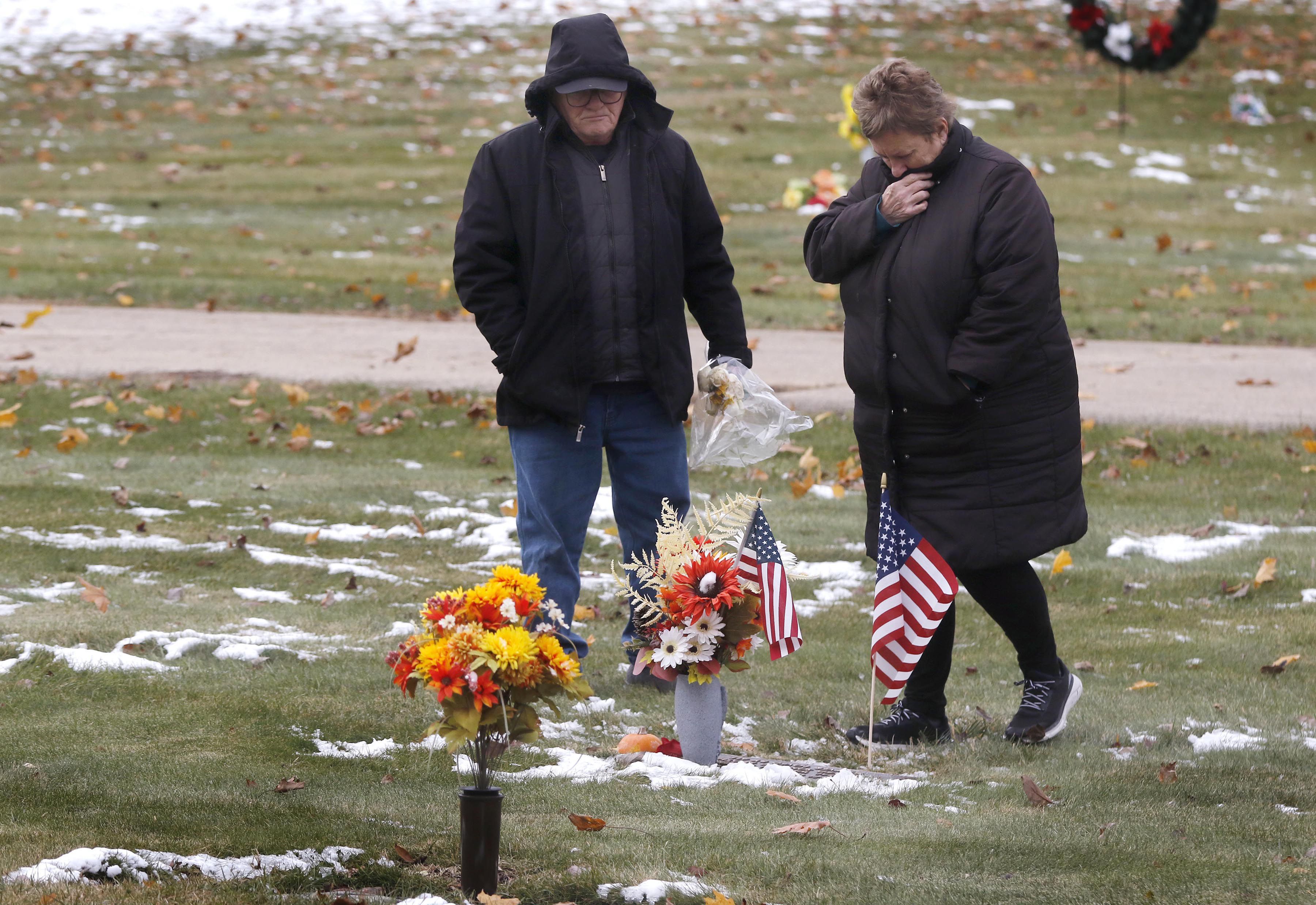Dennis and Melodee Justen visit the gravesite of their son, U.S. Navy veteran Brian Daniel Justen, during the Veterans Day flag placement ceremony Tuesday, Nov. 11, 2025, during the Veterans Day flag placement ceremony Tuesday, Nov. 11, 2025, at McHenry County Memorial Park Cemetery in Woodstock.