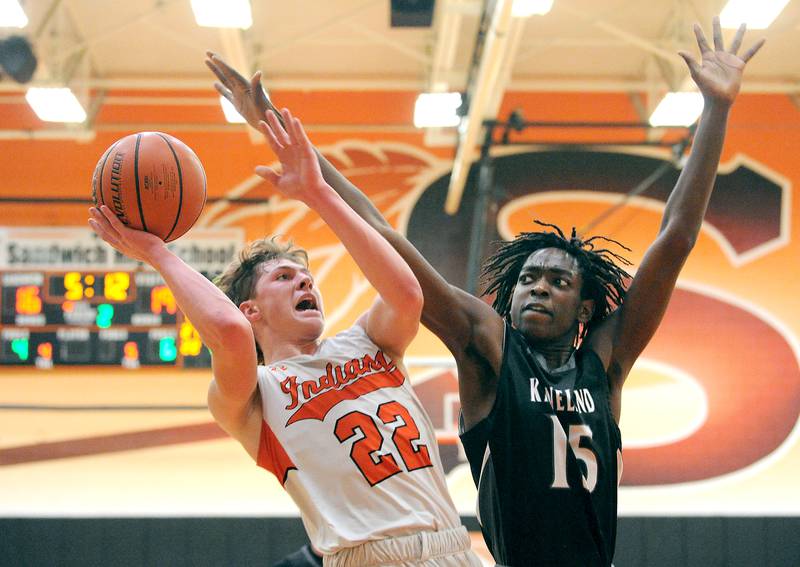 Sandwich's Austin Marks (22) puts up a shot against Kaneland defender Freddy Hassan (15) during a boys' basketball game at Sandwich High School on Friday, Jan. 13, 2023.