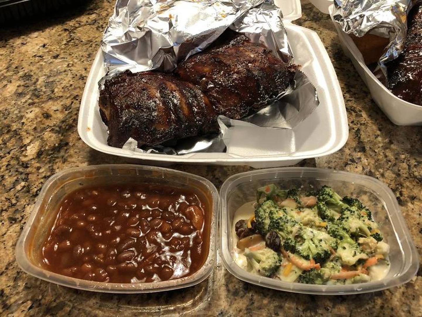 A half slab of Uncle Bub's baby back ribs is accompanied here with baked beans and broccoli salad.