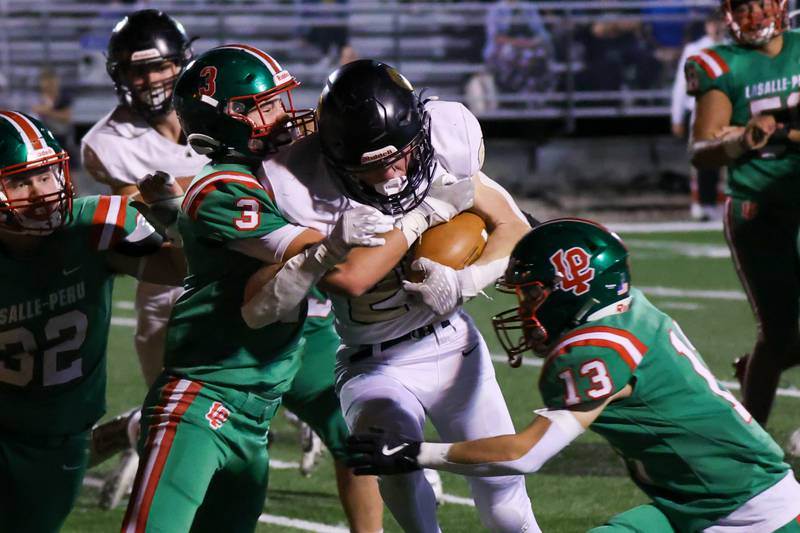 Kevin Lee of Sycamore runs ball whilst Michael Hartman and Gio Legrenzi of L-P attempt to tackle him on Friday, October 11, 2024 at Howard Fellows Stadium in LaSalle.