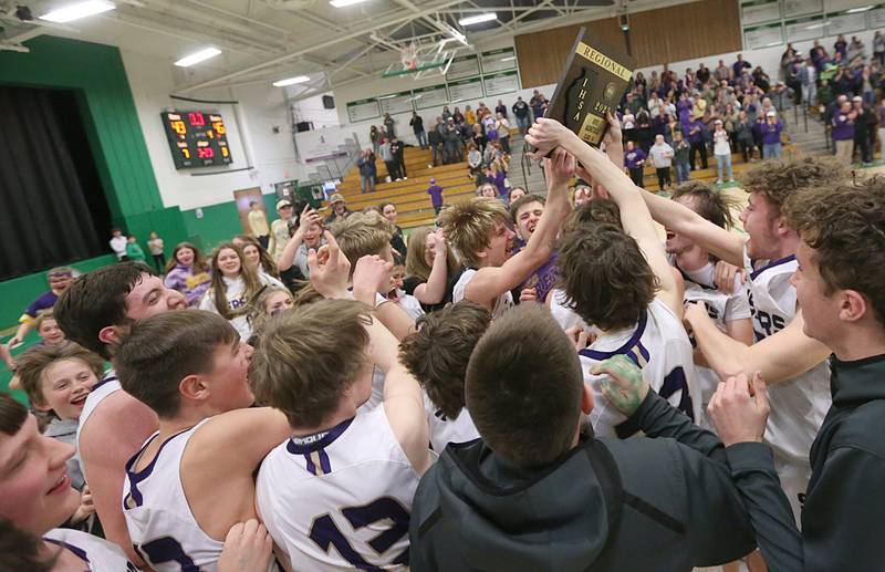 Members of the Serena boys basketball team hoist the Class 1A Dwight Regional championship plaque after defeating Putnam County on Friday, Feb. 24, 2023, at Dwight High School.