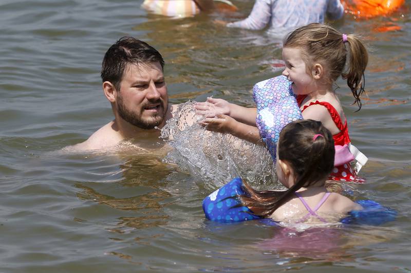 John Hornik swims and plays in the water with his daughters, Maya, 5, and Anna, 3,  at Crystal Lake's Main Beach on Friday, June 21, 2024.