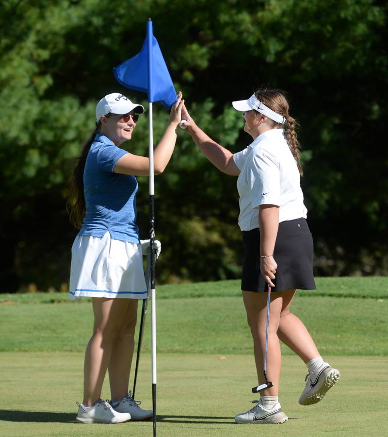 Morrison's Sarah Wetzell (right) gets a high five from Galena's Julia Dominisk after sinking a putt at the 1A regional at Wolf Hollow Golf Course in Lena on Tuesday, Oct. 1, 2024. Wetzell was the sole golfer for Morrison.
