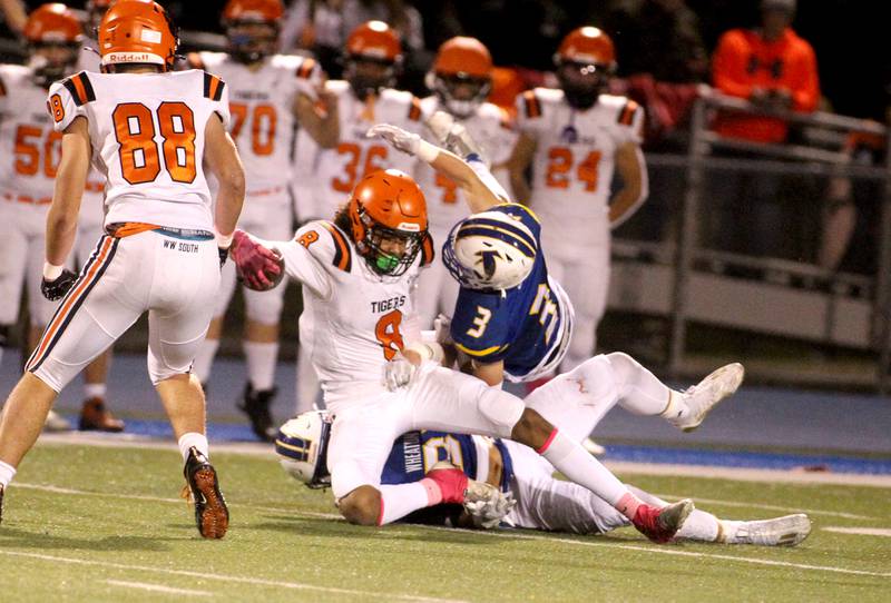 Wheaton Warrenville South’s Braylen Meredith (8) gets tangled up in the Wheaton North defense during a game at Wheaton North on Friday, Oct. 7, 2022.