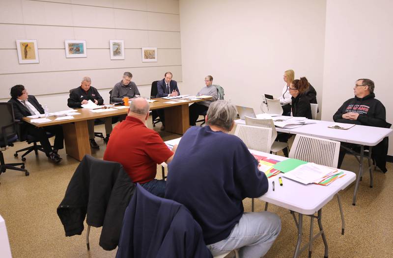 Both parties listen as the City of DeKalb Electoral Board speaks Friday, Jan. 13, 2023, during a hearing to decide if incumbent Scott McAdams, who is running unopposed for DeKalb’s 5th Ward aldermanic seat, should be removed from the ballot due to objections filed by two residents regarding signatures and filing procedure.