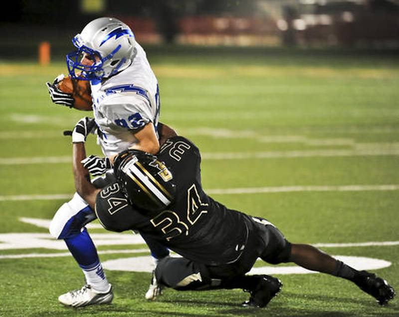 Woodstock's John Kruse tries to break free from Graylake North's Freddie Williams during the first quarter at Grayslake North High School Thursday, September 12, 2013.