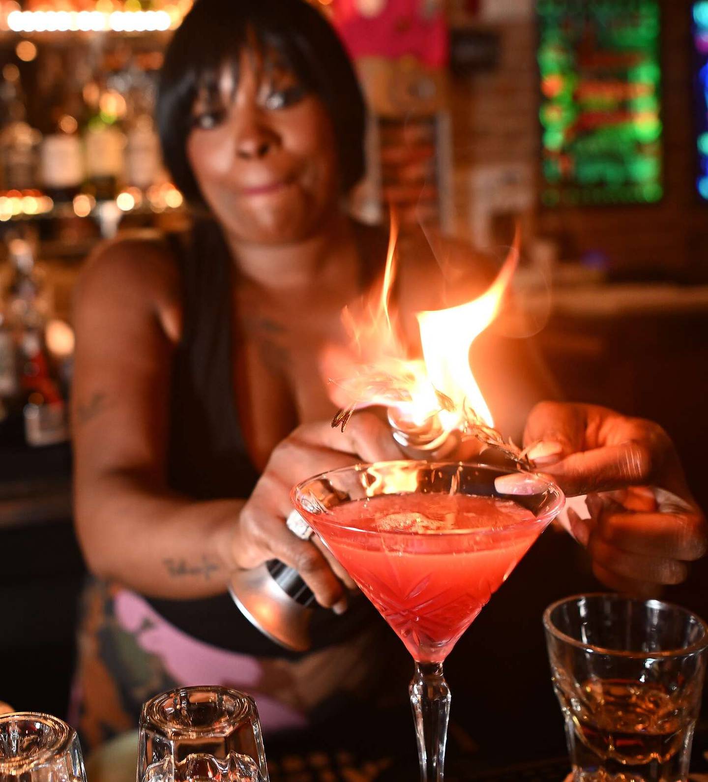 Longtime bartender Tamala Brown lights up rosemary to add a smoky essence to a cocktail.