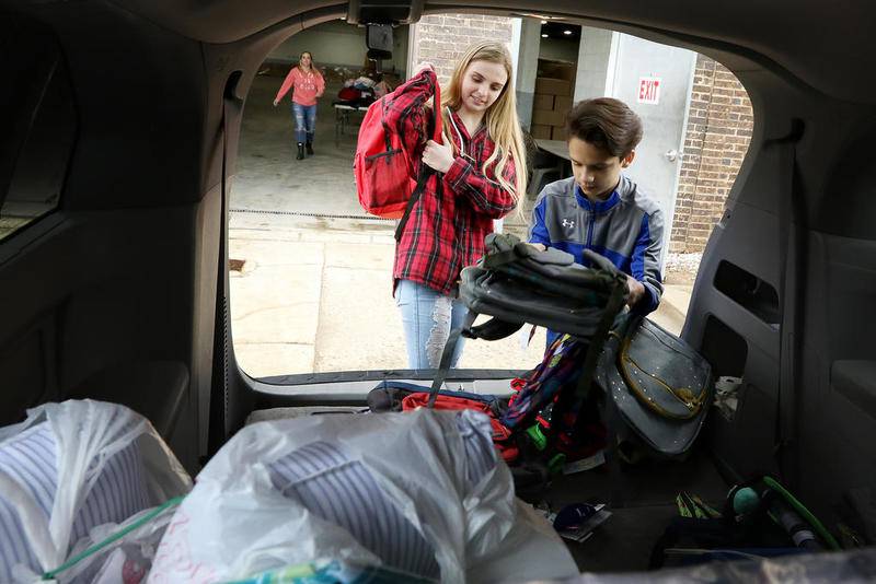 Ainsley Wehby, 15, and brother Isaac, 12, transfer donated items from their mom's vehicle into a warehouse on Monday, April 29, 2019 in Crystal Lake.  The Wehby family is collecting donations for their "Stuff the Duffel" campaign, which will be given to area foster children.