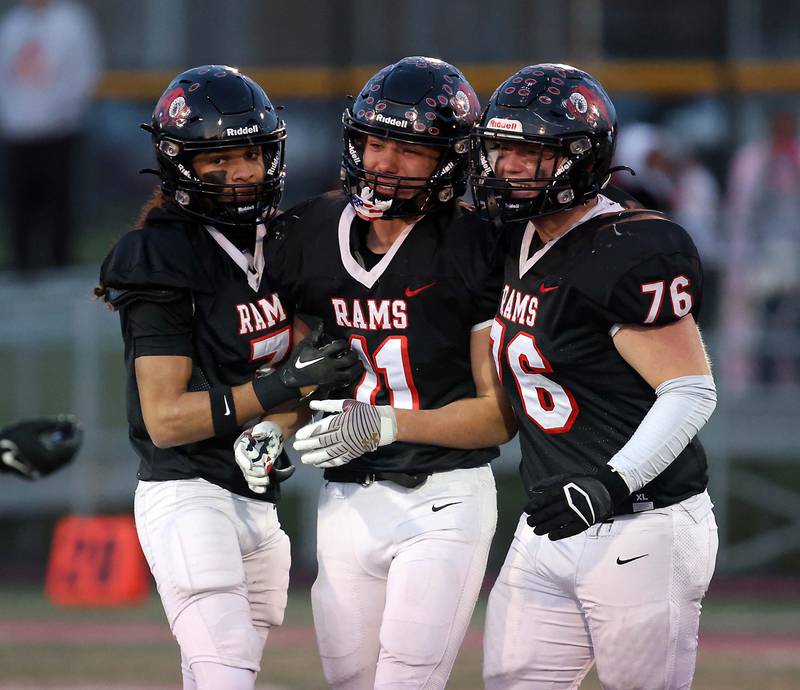 Glenbard East's Stevyn Fox (7) comforts his teammates Aaron Dotson (11) and Cooper Conliss (76) after their loss to Normal in the IHSA Class 7A quarterfinals Saturday November 11, 2023 in Lombard.