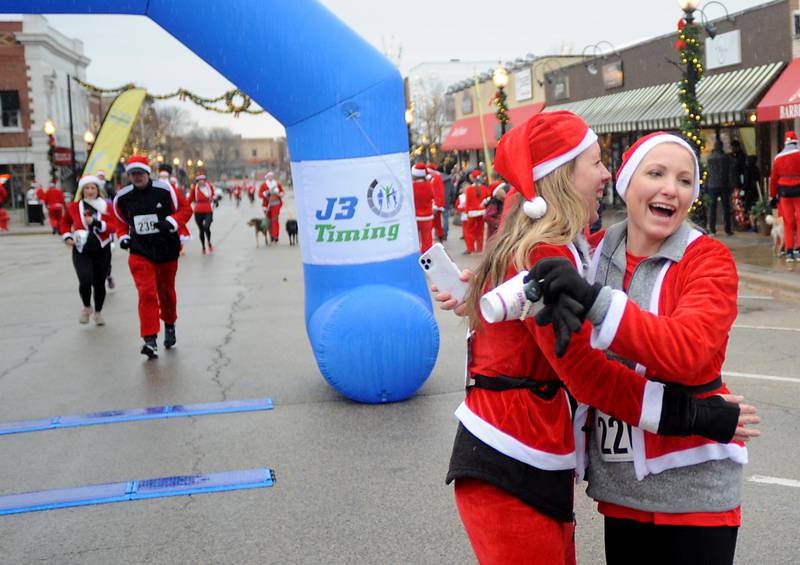 Erin Wagner and Shannon Morrissey hug after running in the McHenry County Santa Run For Kids