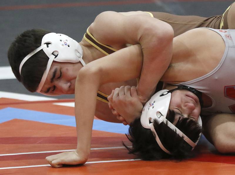 Marian Central's Zane Mochocki tries to get out of the grasp of Mt. Carmel's Justin Williamson in their 132-pound match during a triangle wrestling meet on Saturday Jan. 11, 2025, between Marian Central, Joliet Catholic, and Mt. Carmel at Marian Central High School in Woodstock.