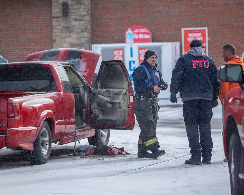 Peru Firefighters talk over situation at scene of internal electrical fire of vehicle near gas pump on Tuesday, December 30, 2025 at Casey's on 1100 Shooting Park Road in Peru. The fire was extinguished by 15 year old driver Jesus Gonzalez of Streator.