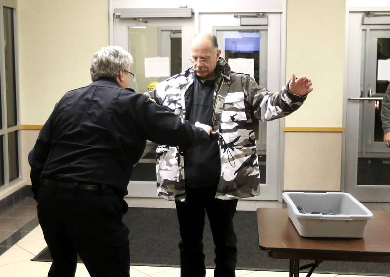 Mike Guy, of McHenry, is checked for weapons by Tom Manchester before entering the McHenry County Administration Building on Tuesday, Feb. 21, 2023, before a McHenry County Board meeting where a resolution opposing the Illinois gun ban was to be voted on.