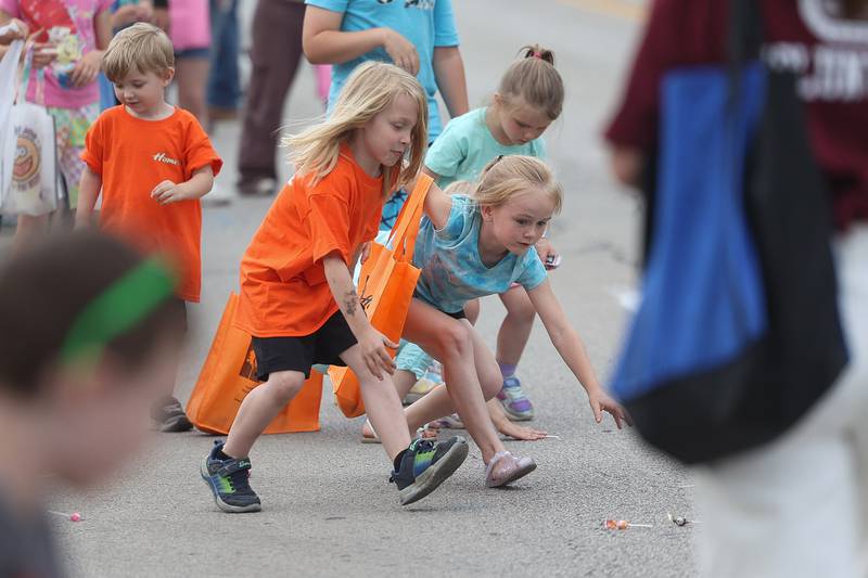 A group of kids races for the candy tossed out in the Old Canal Days Parade on Friday June 7, 2024 in Lockport.