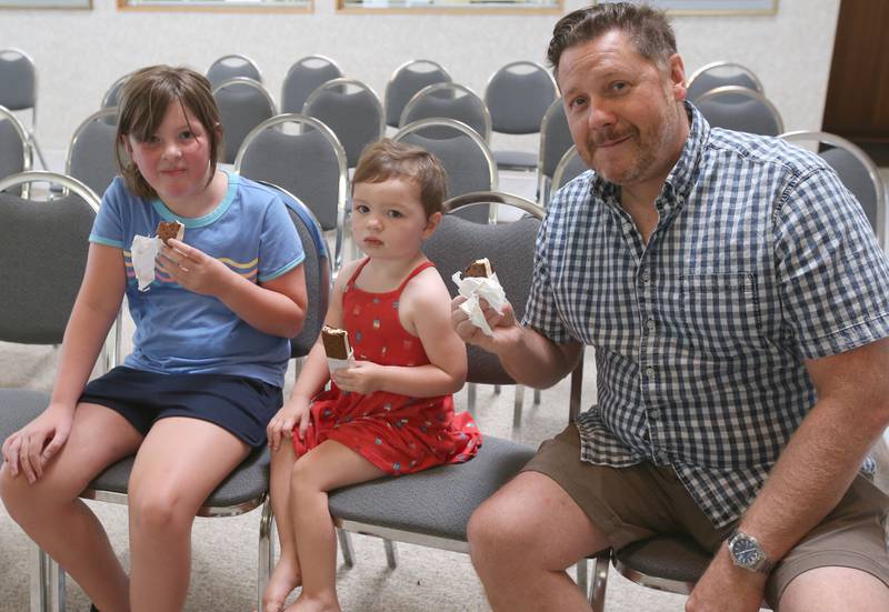 Oglesby mayor Jason Curran shares ice cream bars with Remi Eichelkraut and her sister Rylan on Wednesday, Aug. 23, 2023 at the Oglesby City Hall. Mayor Curran celebrated his birthday by handing out free ice cream bars and popsicles as a treat to beat the heat.