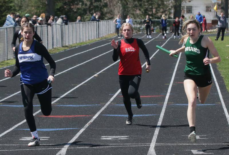 St. Bede's Anna Lopez (right) wins the 4x100 relay as Newark's Brooklyn Hatteberg (left) comes in second followed by Hall's Molly Dalzot during the Rollie Morris Invite on Saturday, April 16, 2022 at Hall High School in Spring Valley.