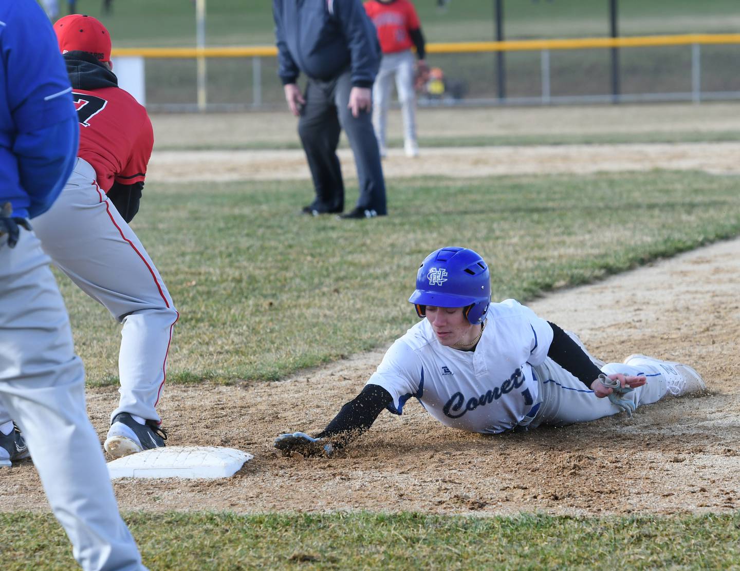 Newman's Garrett Matznick dives safely back to first during a Wednesday, April 5 game in Forreston.