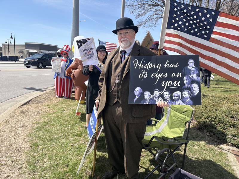 Diane Ayers, left and Rusty Ayers, wear outfits from the era of women's suffrage at a No Kings rally in Crystal Lake, Saturday, March 28, 2026.