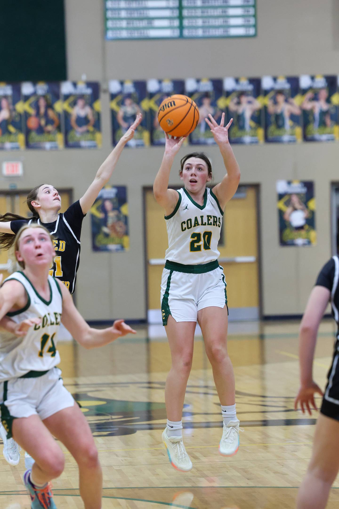 Coal City's Laura Christopher hits a 3-pointer as Reed-Custer's Alyssa Wollenzien defends during the Comets' 50-43 victory over Coal City on Monday, Jan. 11, 2026.