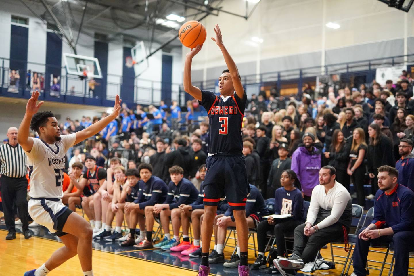 Oswego’s Ethan Vahl (3) shoots a three pointer against Oswego East's Torrin Ross (23) during a basketball game at Oswego East High School on Saturday, January 11, 2025.