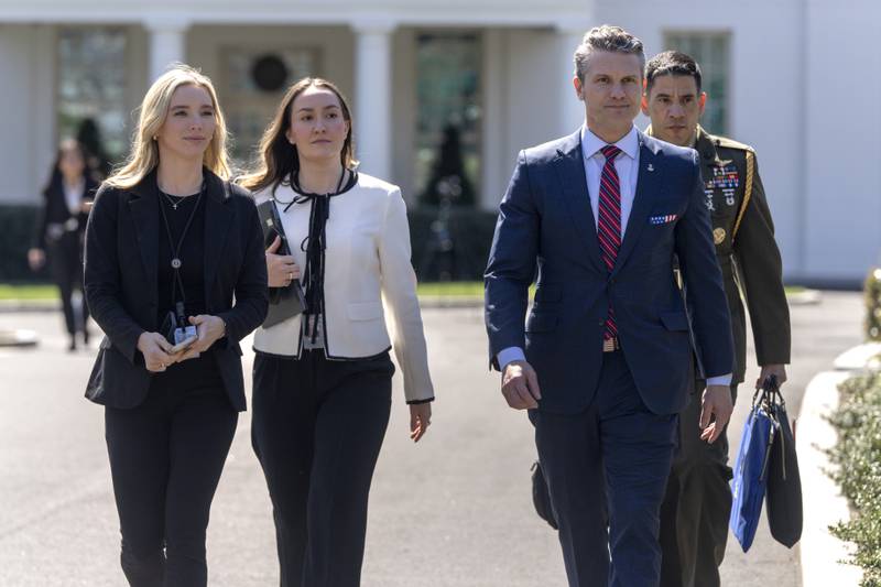 Defense Secretary Pete Hegseth, second from right, walks outside the Oval Office at the White House, Friday, March 21, 2025, in Washington. (AP Photo/Mark Schiefelbein)