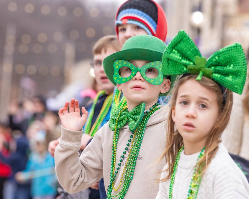 A parade attendee waves to the firetrucks as they go by during the St. Patrick's Day Parade on March 7, 2026 in Utica.