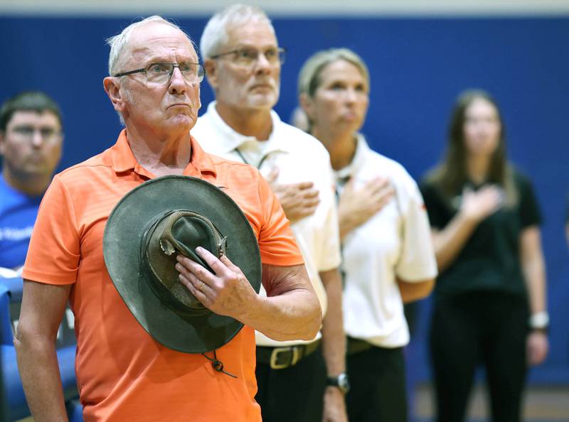 U.S. Navy veteran Jim Kush stands during the national anthem Tuesday, Sept. 5, 2023, at Genoa-Kingston High School before fulfilling his duties as official score keeper for the Genoa-Kingston volleyball team. Kush has also sung the national anthem at Genoa-Kingston sporting events.