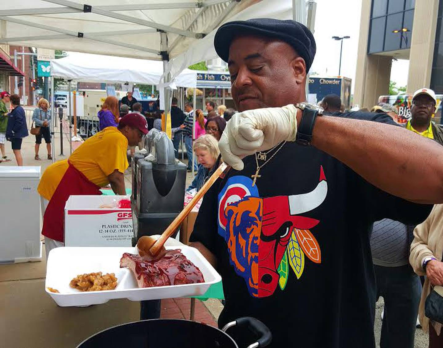 Dennis Beale, with Louisiana Barbeque in Joliet, pours barbecue sauce over a slab of ribs Friday night during the Joliet Region Chamber of Commerce and Industry's New Orleans North festival in downtown Joliet.