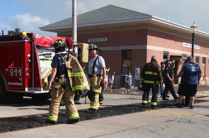 Firefighters walk to their trucks as they battle an apartment fire in the 800 block of Main Street on Monday, Aug. 22, 2022 in Mendota.