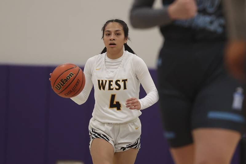 Joliet West’s Christina Keoborakot works the ball up court against Joliet Catholic in the WJOL Basketball Tournament at Joliet Junior College Event Center on Monday