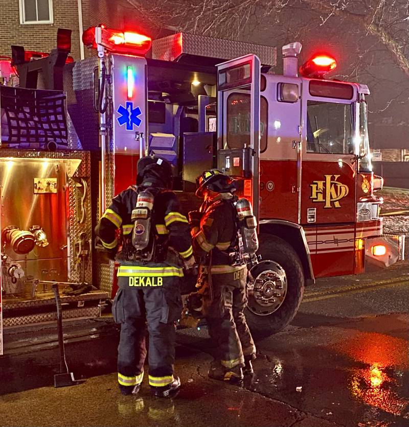 Two DeKalb firefighters don their gear as they prepare to join the crews fighting a multi-building apartment fire on Sunday, Dec. 22, 2024, in the 1000 block of West Hillcrest Drive in DeKalb.