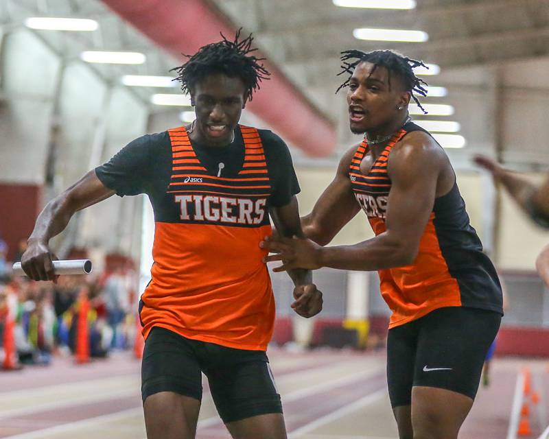 Wheaton Warrenville South's Amari Williams is met at the finish by Da'jion Riley for the win in the 4x200 during DuKane Boys Indoor Track and Field Conference Championships. Mar 16, 2024