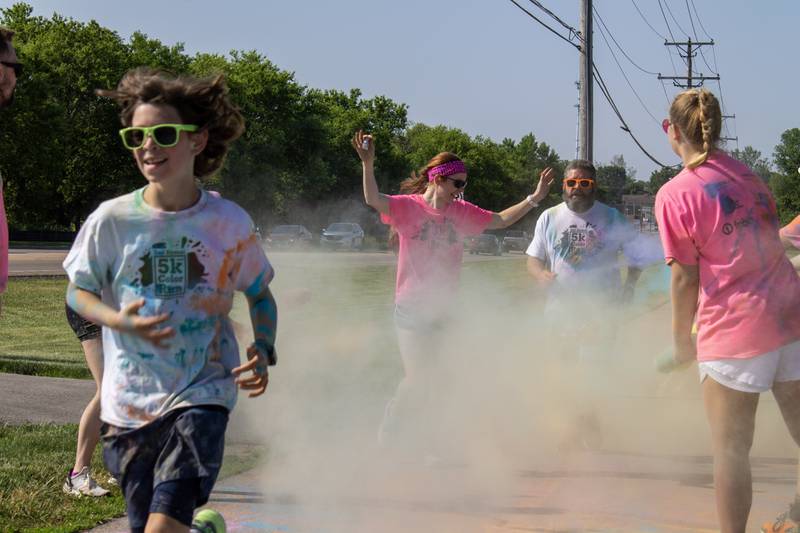 Participants run through a cloud of color as they pass the first color station on their way back to Sycamore Middle School during CASA DeKalb County's annual 5K Color Run Saturday, June 3, 2023. The course consisted of four color stations and two water stations.