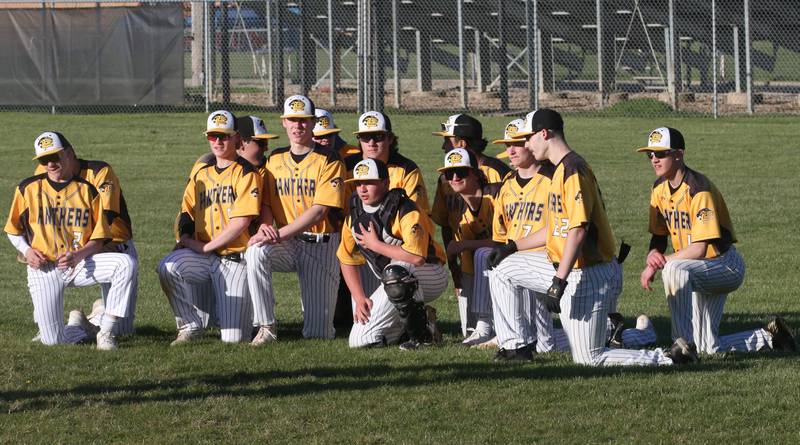 Members of the Putnam County baseball team take a knee as they gather in the outfield after defeating Woodland/Flanagan-Cornell on Tuesday, April 9, 2024 at Woodland High School.