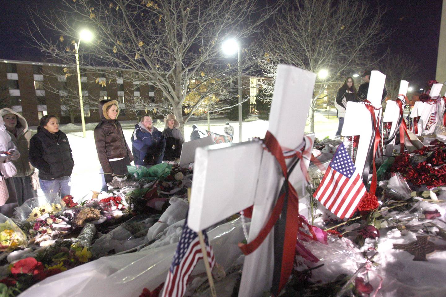 Shaw Local Feb. 14, 2008 file photo – Students visit crosses erected at the top of a hill within eyesight of Cole Hall, the location of Thursday’s shooting rampage on the DeKalb campus of Northern Illinois University.