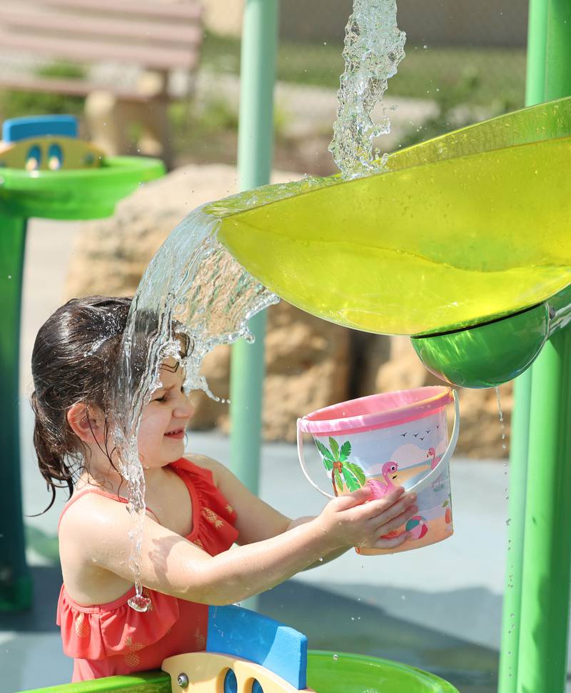 Tillie Arrecis, from Sycamore, tries to fill her bucket Wednesday, Aug. 23, 2023, at the Sycamore Park District Splash Fountain splash pad. Temperatures climbed into the high 90’s Wednesday with more hot weather expected Thursday.
